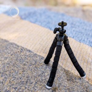 FlexiMount tripod standing open on a camping mat, ready for use with lanterns or devices