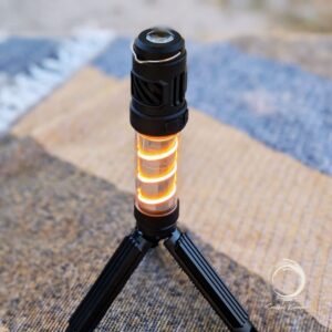 Silent Lantern glowing orange on tripod outdoors