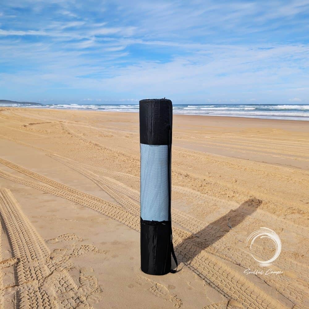 Soulful Mat rolled up in carry bag standing upright on beach sand