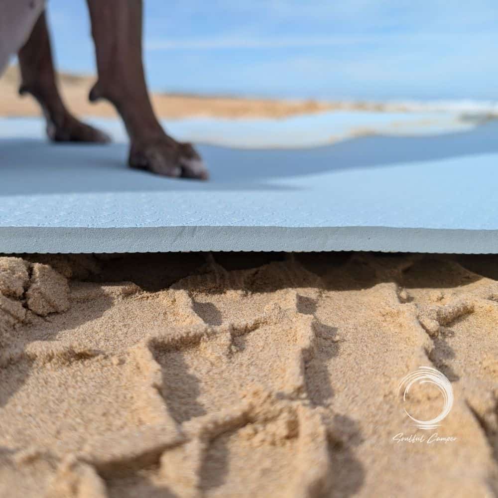 Side view of Soulful Mat showing its thickness and placement on sand