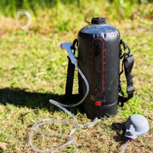 Soulful Camper 12L Sun Shower with hose, pump, and shoulder strap on grassy ground