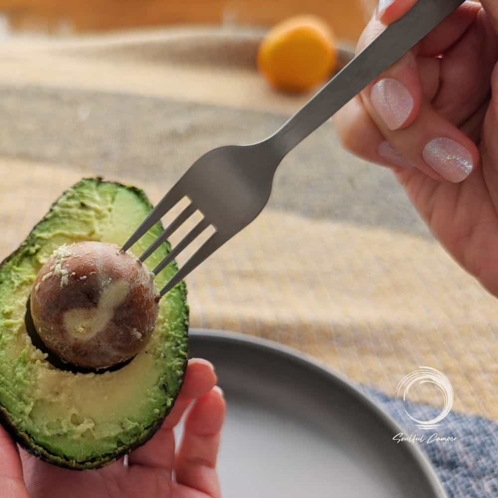 Titanium camping fork removing avocado pit – lightweight and durable outdoor dining utensil by Soulful Camper.