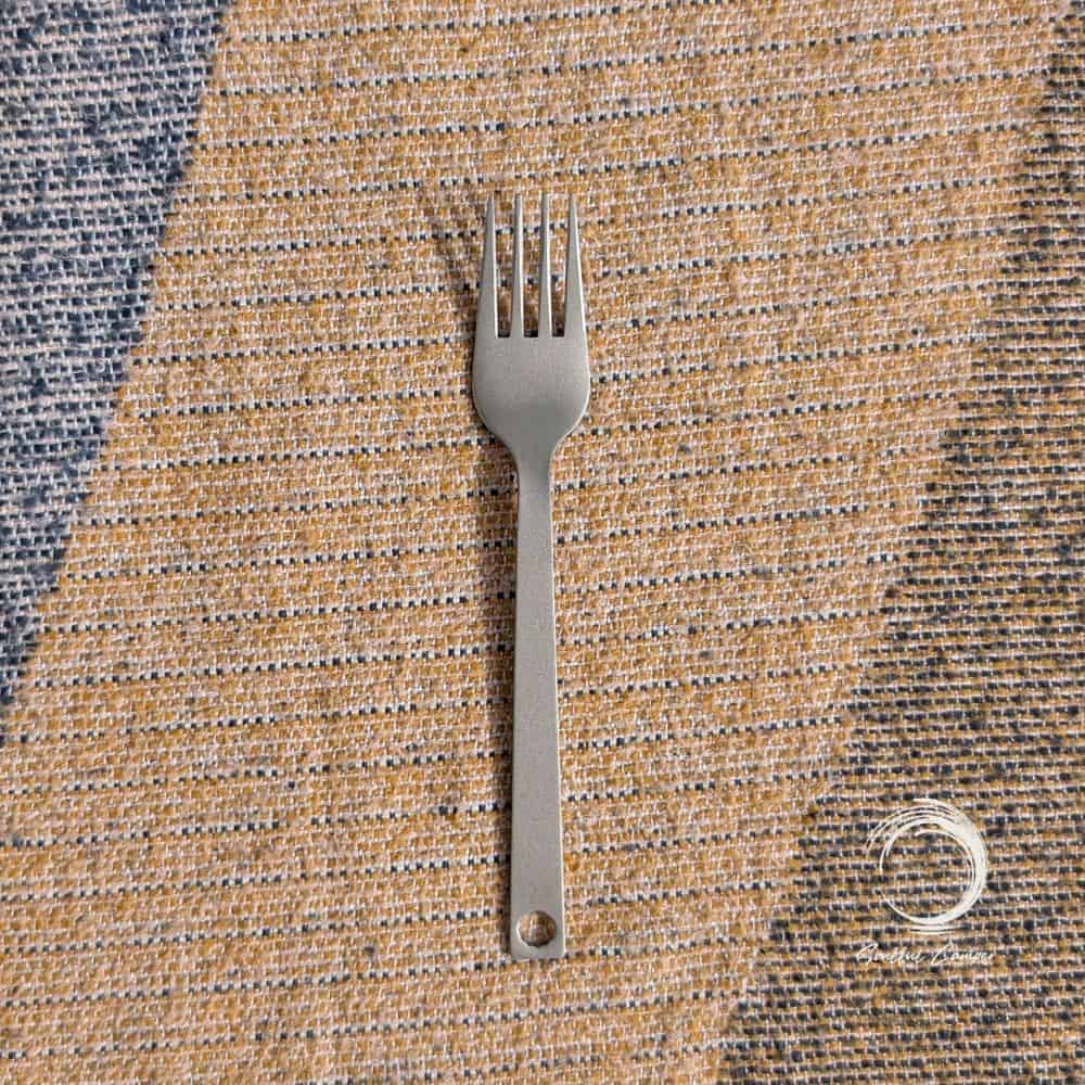 Titanium camping fork on woven outdoor blanket – lightweight, rustproof and eco-friendly Soulful Camper cutlery.